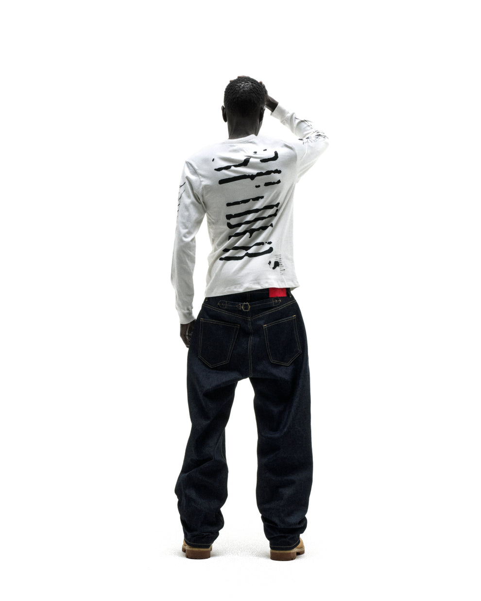 WAIT LONGSLEEVE: White 100% cotton long sleeve tee with black graphic print on back, worn by a person from behind.