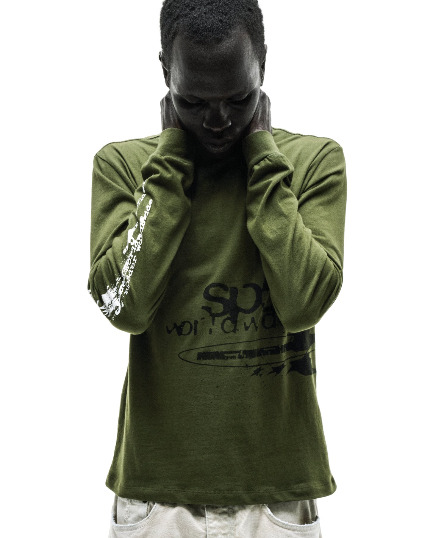 Man in olive green cotton long sleeve tee with black and white graphic prints, ribbed collar and cuffs.