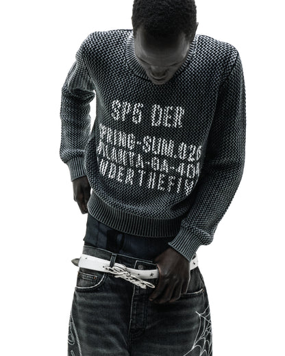 Black knit cotton sweater with white text print at chest, worn by a man.