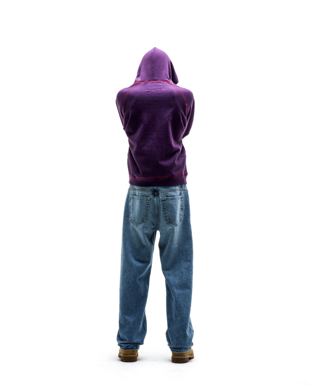 Purple SPLAT COLLISION HOODIE with contrast stitching, kangaroo pocket, and rib knit details, paired with jeans.