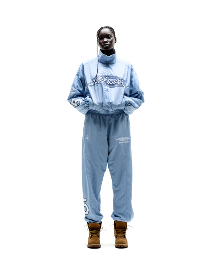 Light blue nylon track jacket and matching pants with embroidered logos, worn by a model.