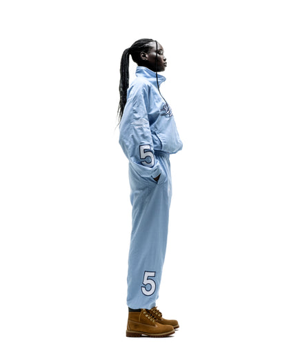 Light blue nylon track jacket and pants set with embroidered chest logo, sleeve graphic, and large "5" on pants.
