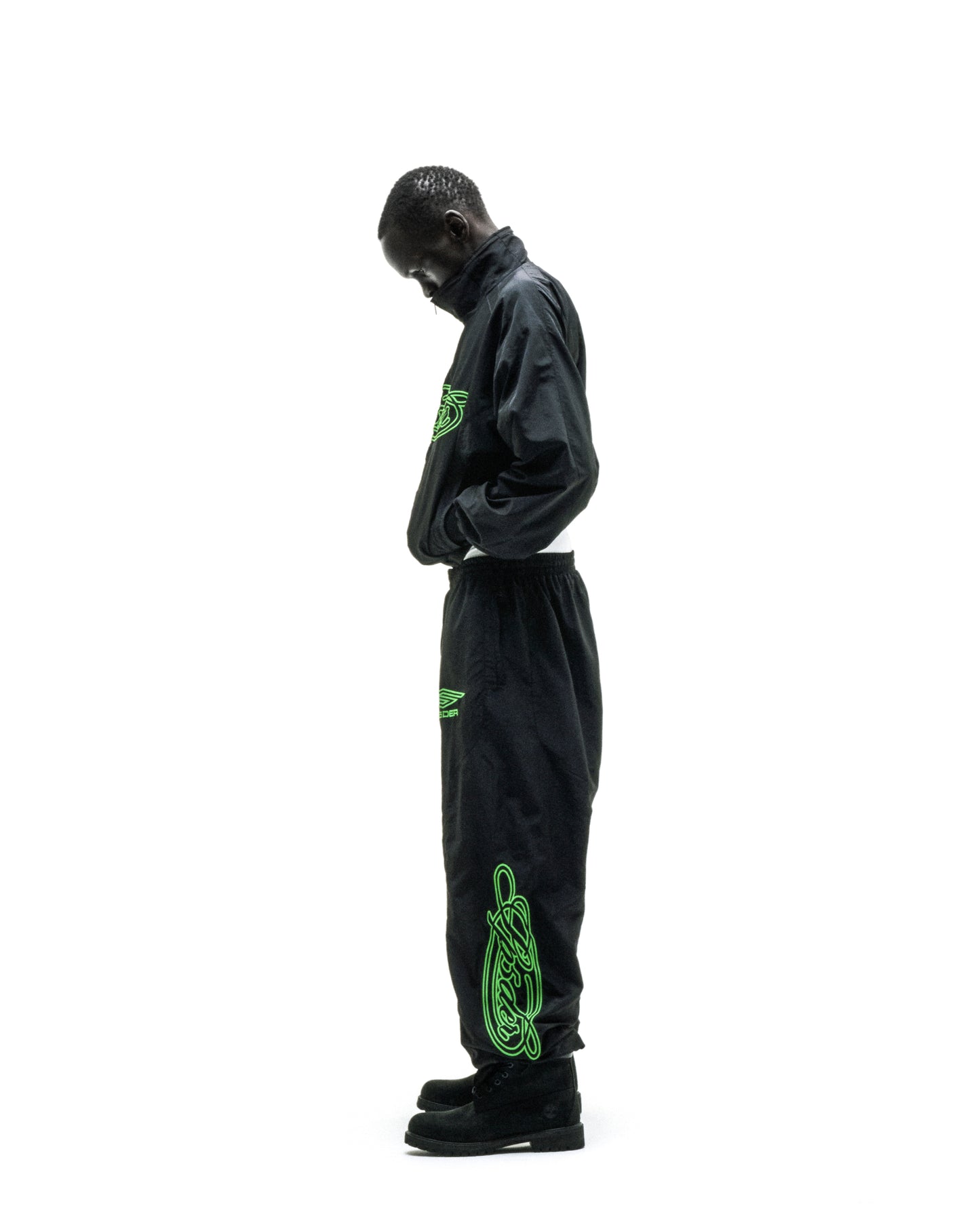 Black nylon track jacket and pants with neon green embroidered logos and sleeve graphic.