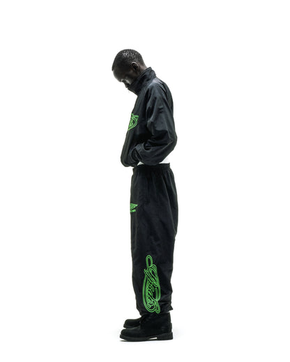 Black nylon track jacket and pants with neon green embroidered logos and sleeve graphic.