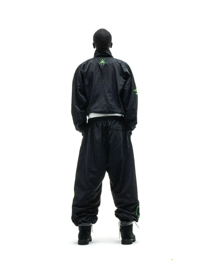 Black nylon SCRIPT Warm Up Jacket and pants with green embroidered logos, viewed from behind.