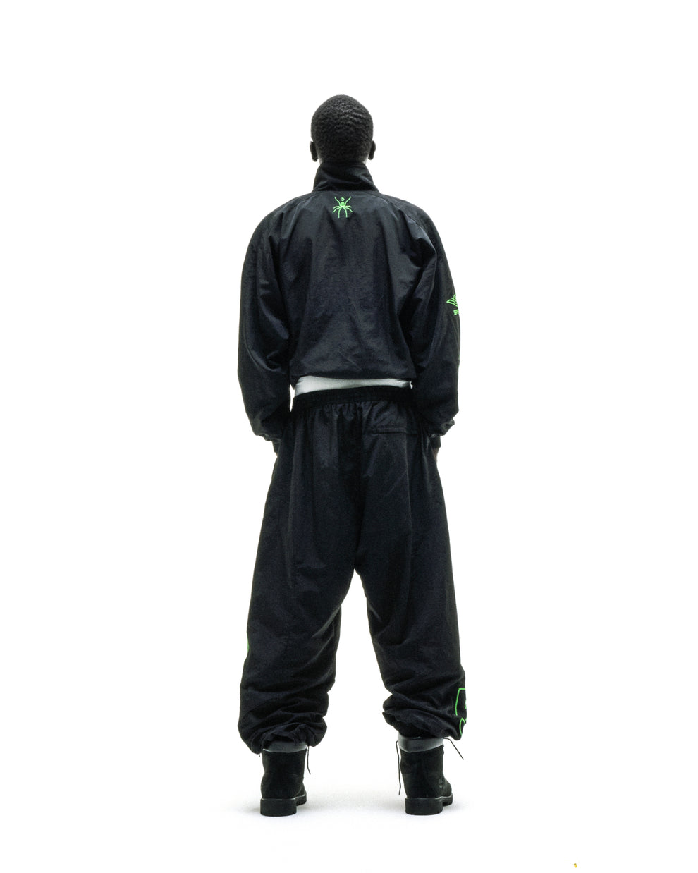 Black nylon SCRIPT Warm Up Jacket and pants with green embroidered logos, viewed from behind.