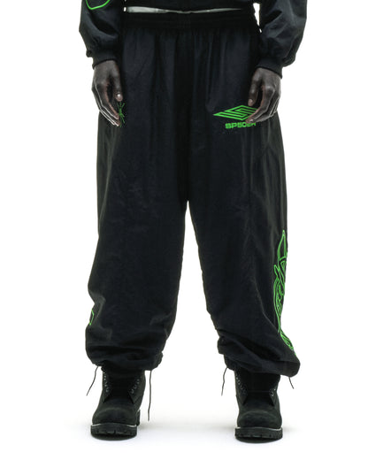 Black nylon track pants with green embroidered graphics and elasticized cuffs.