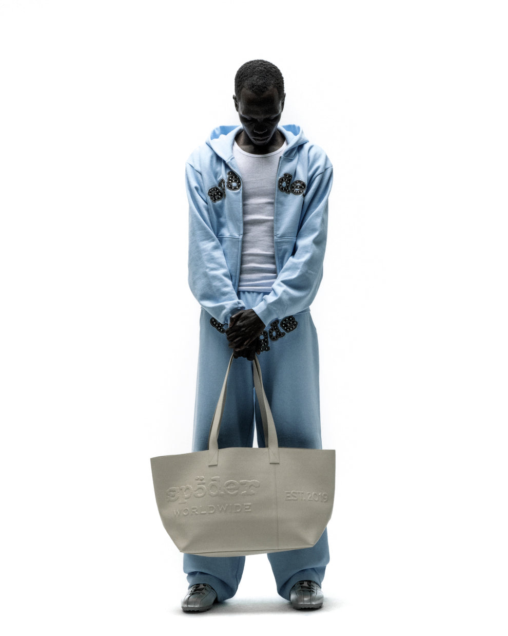 Light gray genuine leather tote bag with embossed "SP5DER WORLDWIDE" logo and "EST. 2019" detail.