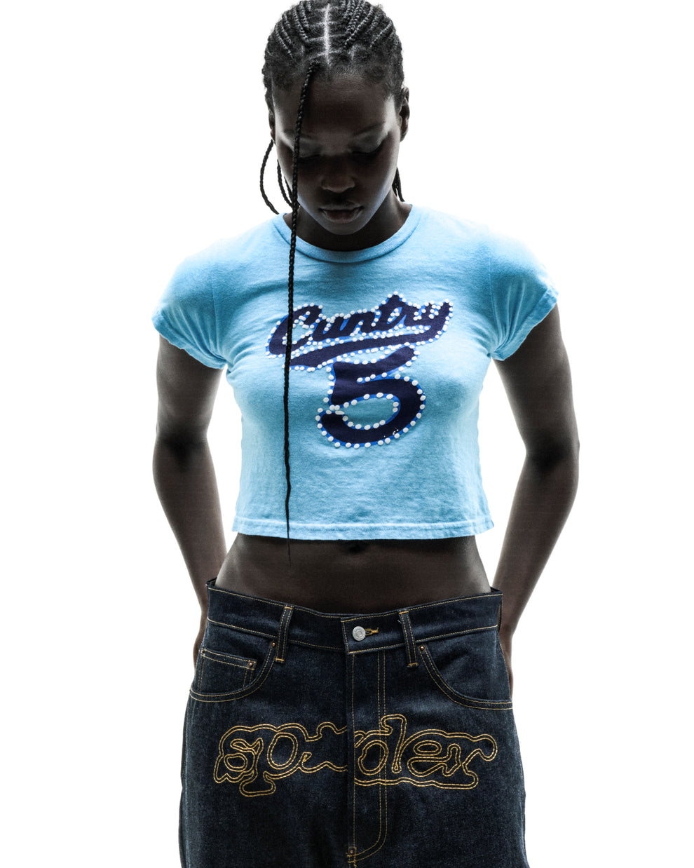 Woman in a light blue cropped cotton/spandex tee with "CUNTRY 5" graphic and dark denim jeans.