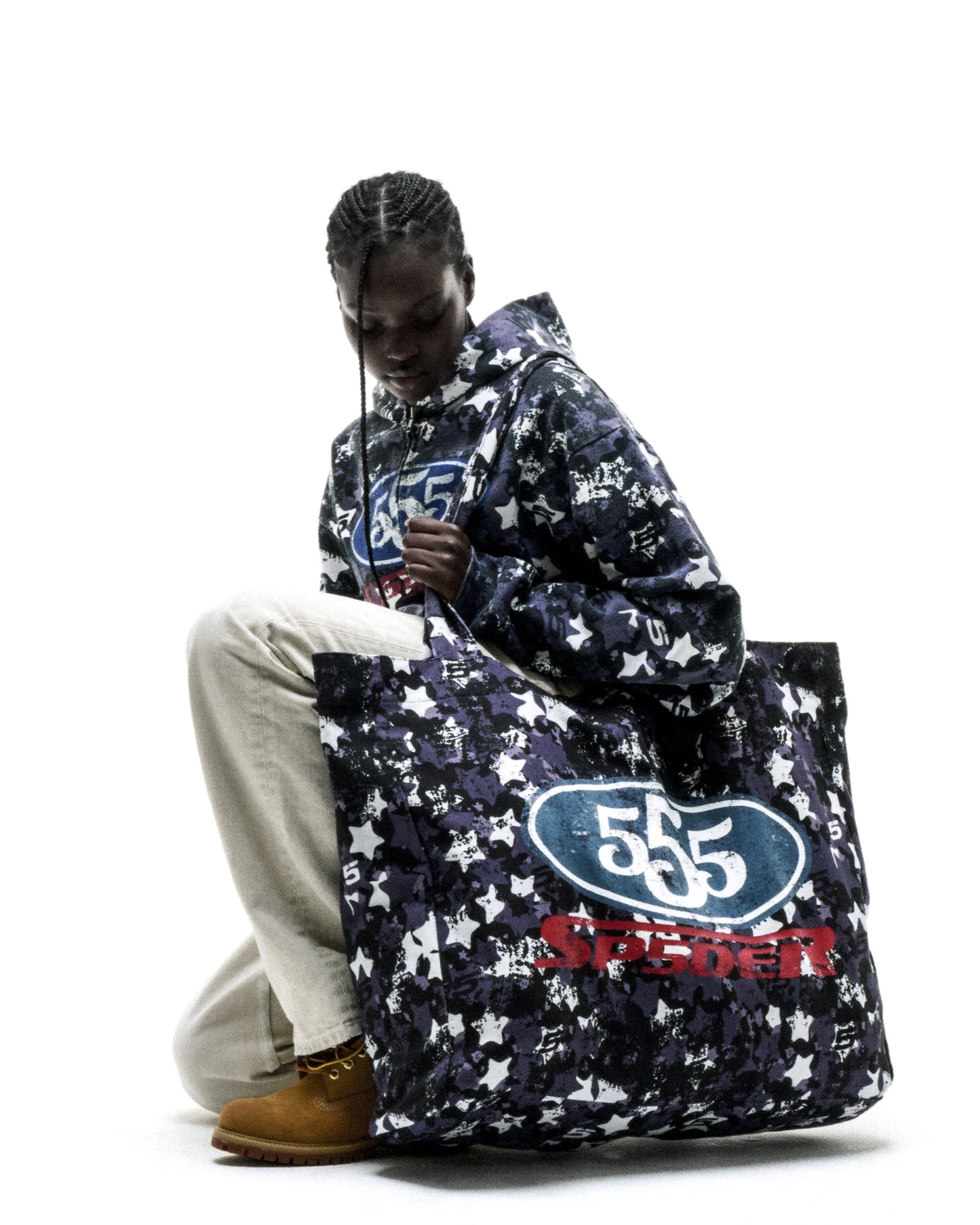R5CING TOTE BAG: Dark blue star camo brushed twill tote with "555" logo, held by a model.