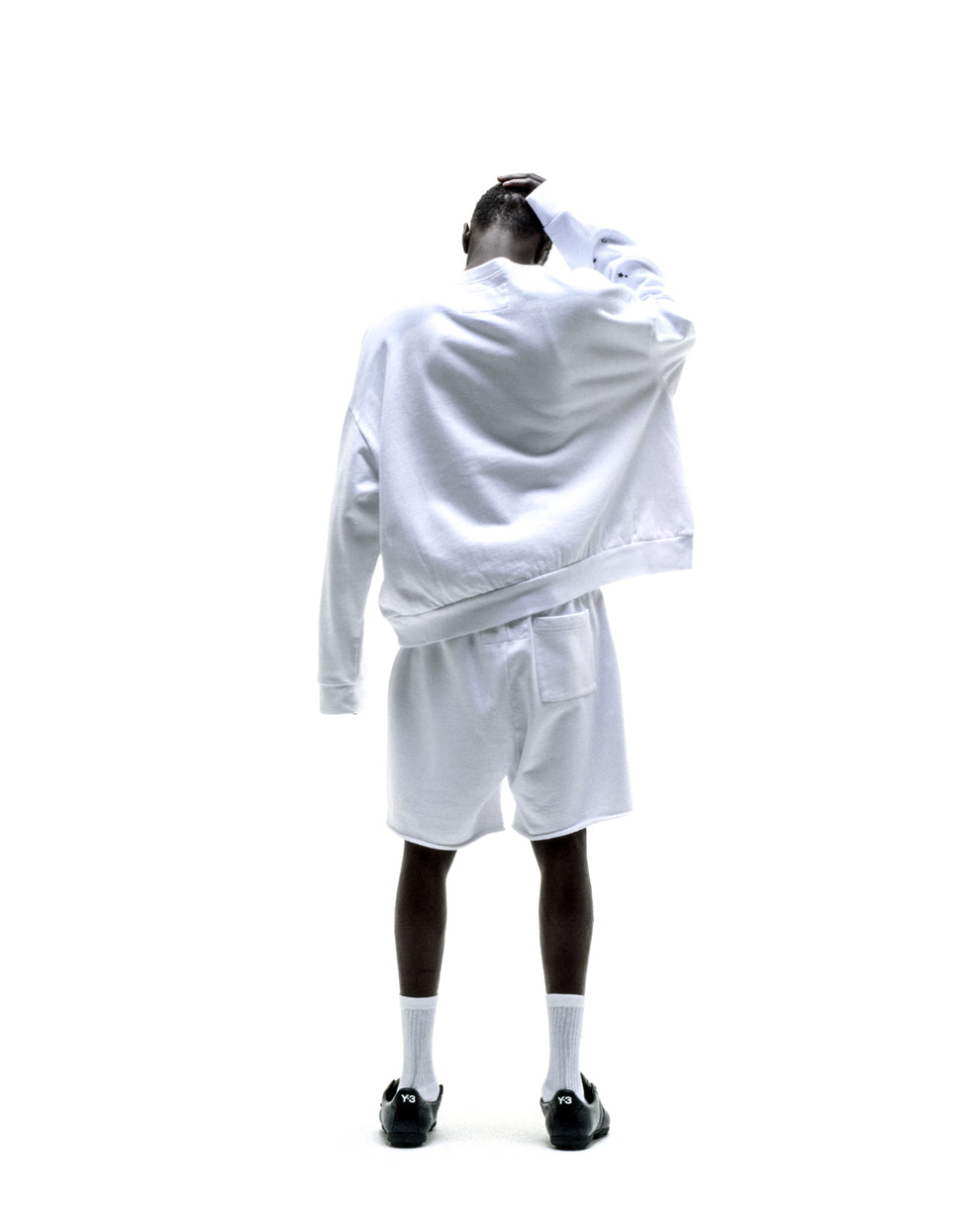 White VARSITY WEB CREWNECK and shorts set on a model, back view.