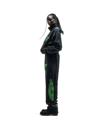 Black nylon track jacket and pants with green embroidered logos and sleeve graphic.