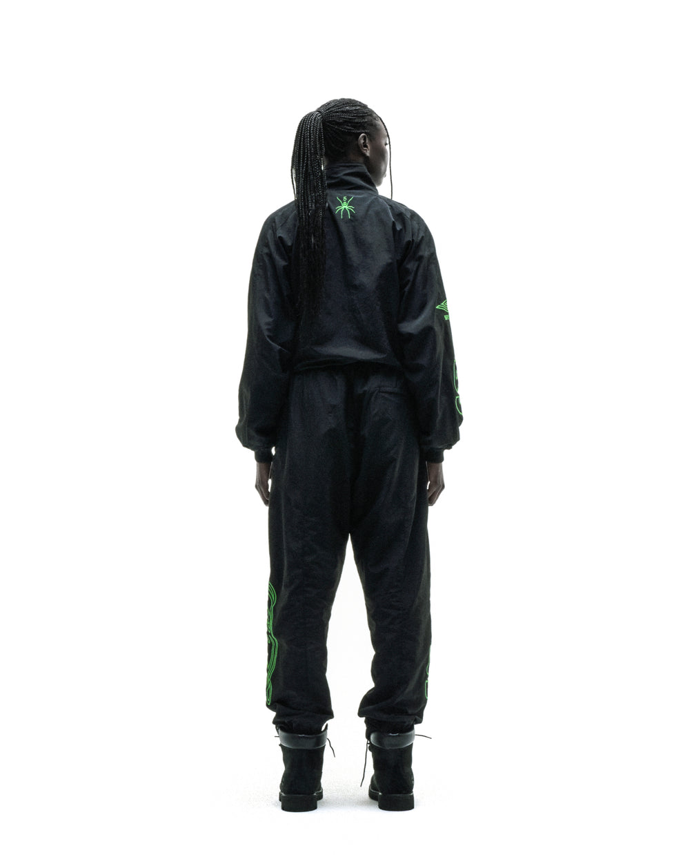 Black nylon track jacket and pants set with green embroidered graphics, elastic cuffs, and hem.
