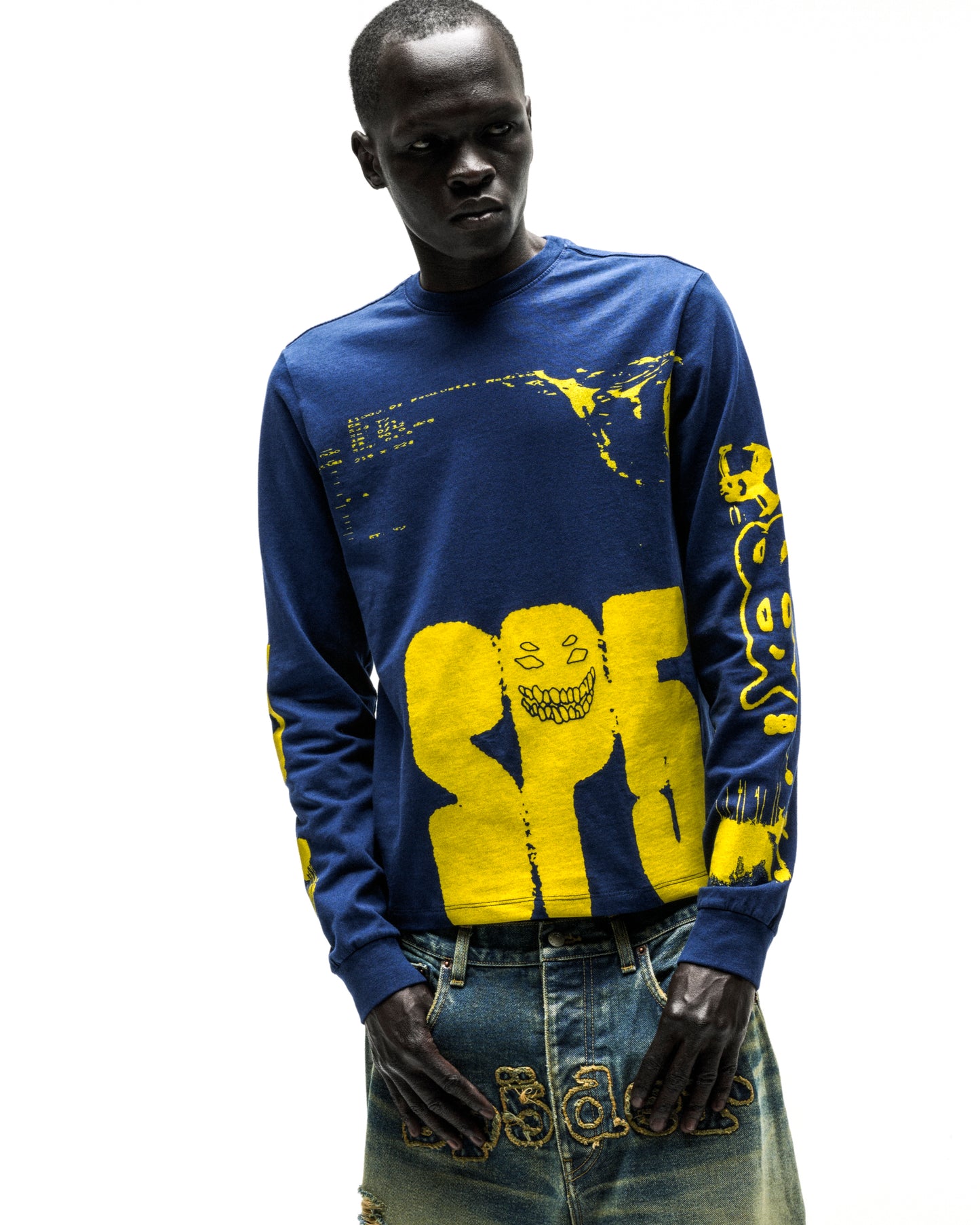 Model in a navy blue 100% cotton X-RAY LONGSLEEVE with yellow graphic print on front, back, and sleeves.