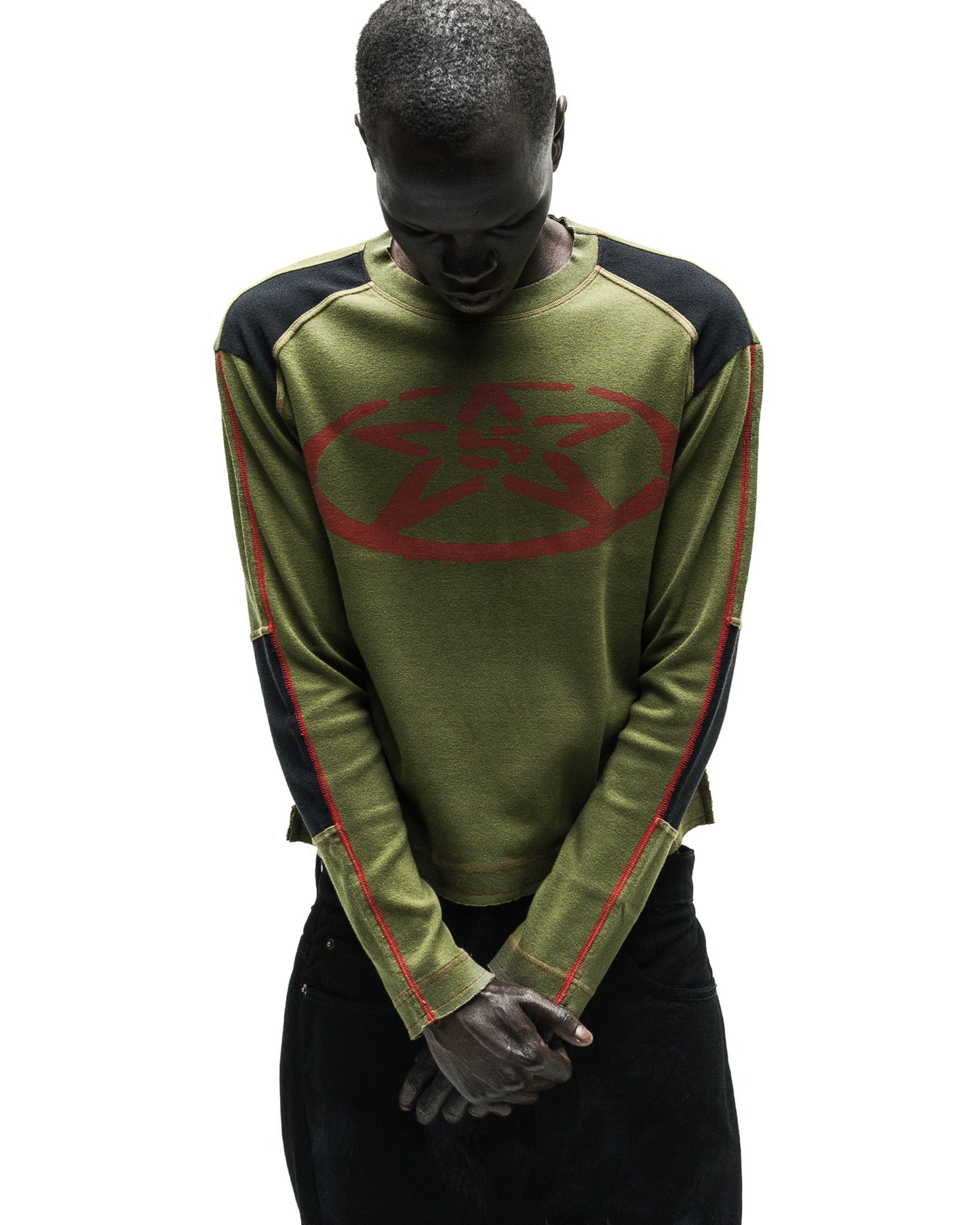 Olive green knit SERVICE LONGSLEEVE with red star logo, black shoulder panels, and red seam detailing.