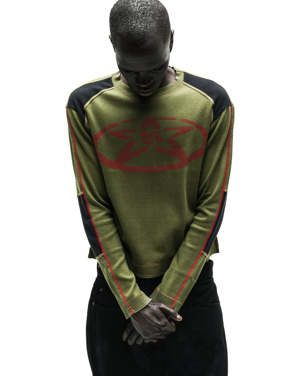 Olive green knit SERVICE LONGSLEEVE with red star logo, black shoulder panels, and red seam detailing.