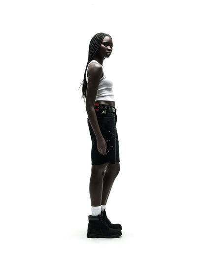 Black HEAVY WEB JEAN SHORTS with silver studs, worn by a model with a white tank top and black boots.