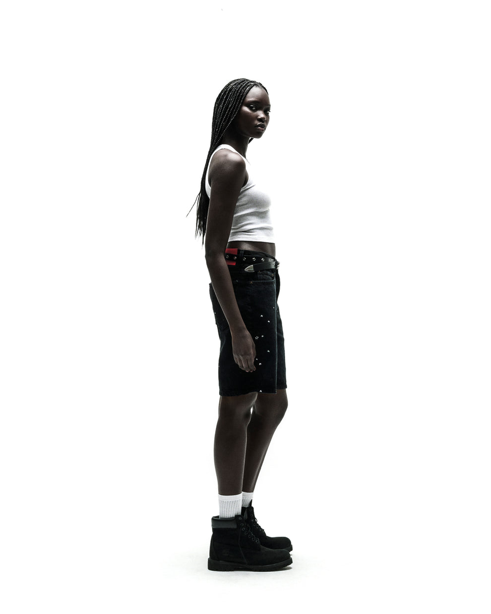 Black HEAVY WEB JEAN SHORTS with silver studs, worn by a model with a white tank top and black boots.