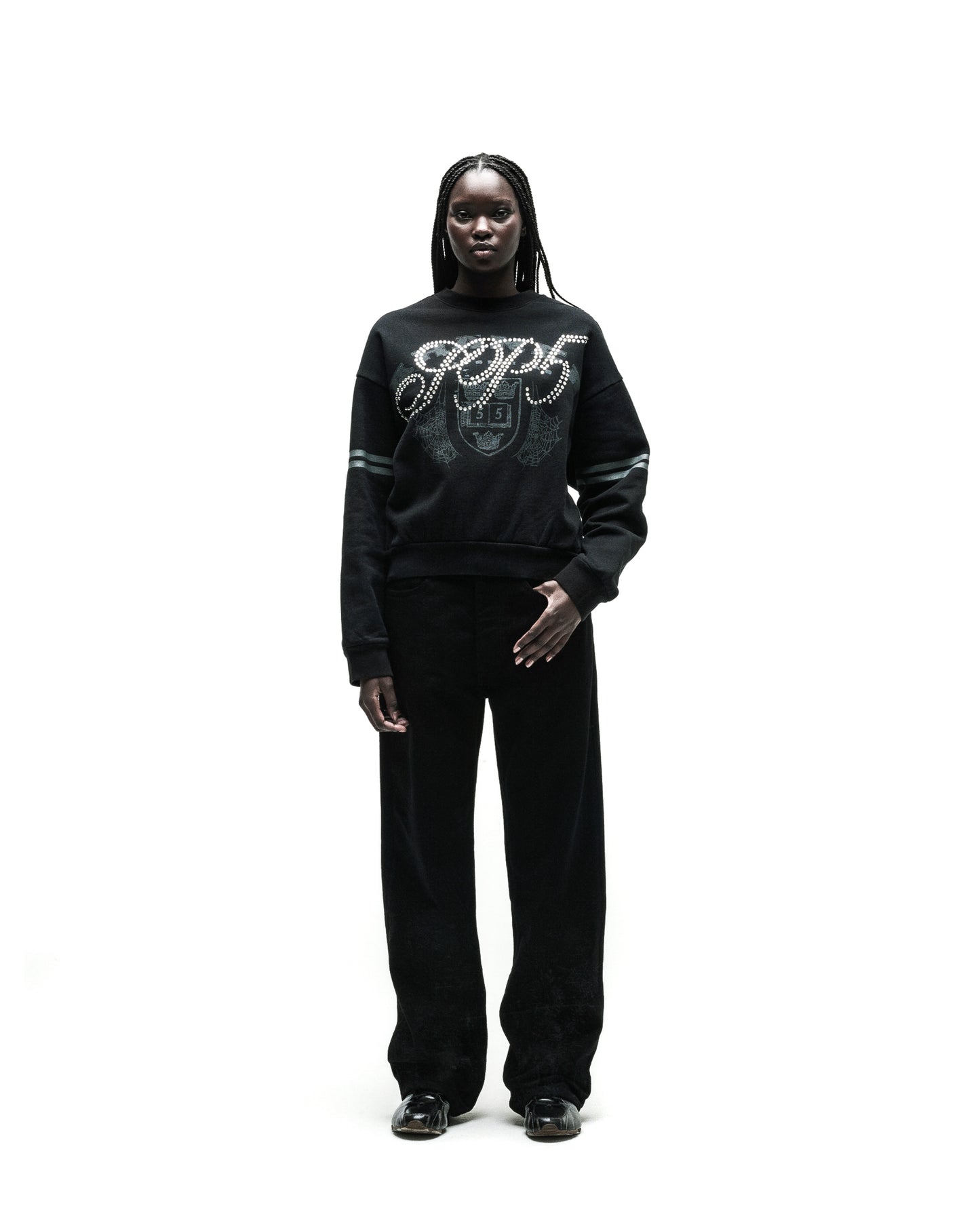 Black ARANEA CREWNECK sweatshirt with "GCDS" logo and pearl embellishments, paired with black pants.