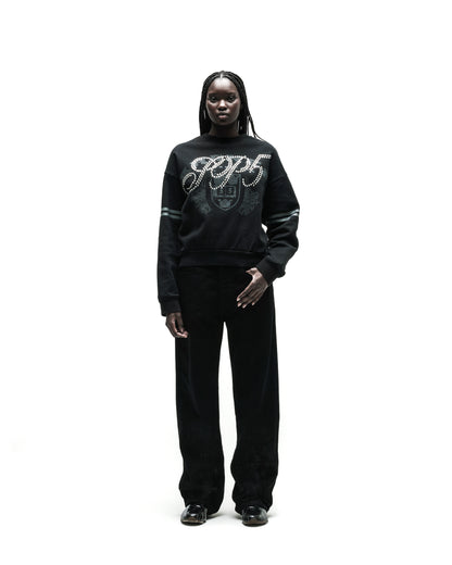 Black ARANEA CREWNECK sweatshirt with "GCDS" logo and pearl embellishments, paired with black pants.