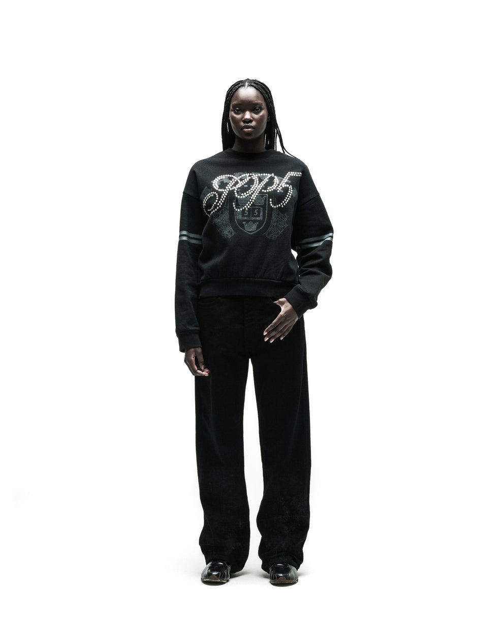 Black ARANEA CREWNECK sweatshirt with "GCDS" logo and pearl embellishments, paired with black pants.