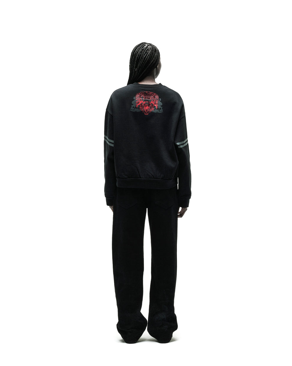 Black ARANEA CREWNECK with red spider graphic on back, grey sleeve stripes, and black wide-leg pants.