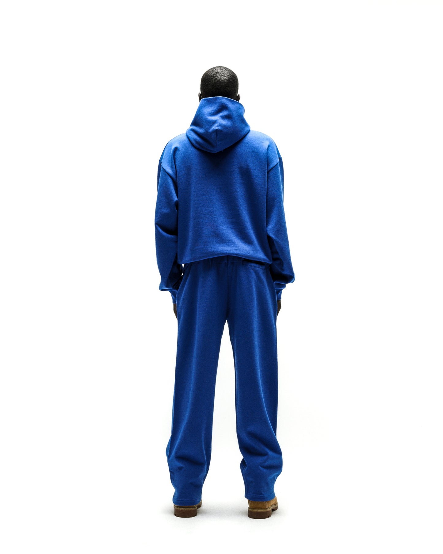 Back view of a person wearing a blue RHINESTONE PUNK V2 HOODIE and matching sweatpants.