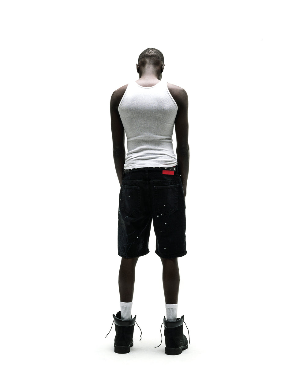 Black denim Heavy Web Jean Short with silver studs, red tag, and black boots.